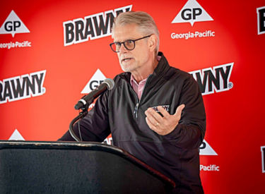 a man standing at a podium with a microphone
