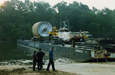 a group of people standing next to a barge
