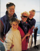 A photo of Charles Koch and family standing on a boat, with daughter Elizabeth and wife Liz holding up freshly caught fish.