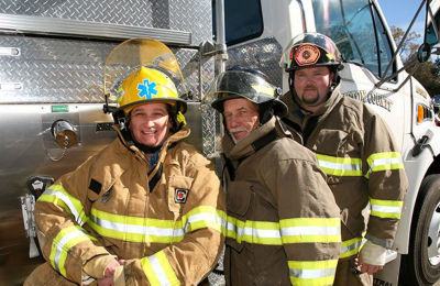 a group of firefighters standing in front of a truck