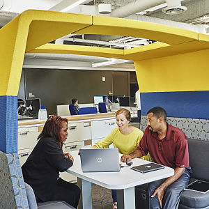 a group of people sitting at a table with a laptop