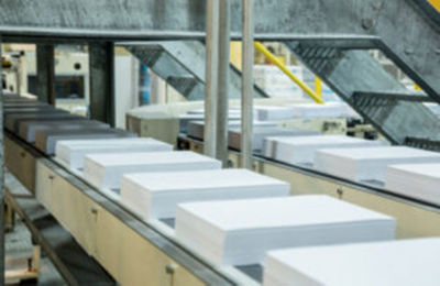a conveyor belt with white paper
