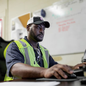 a man in a safety vest using a computer
