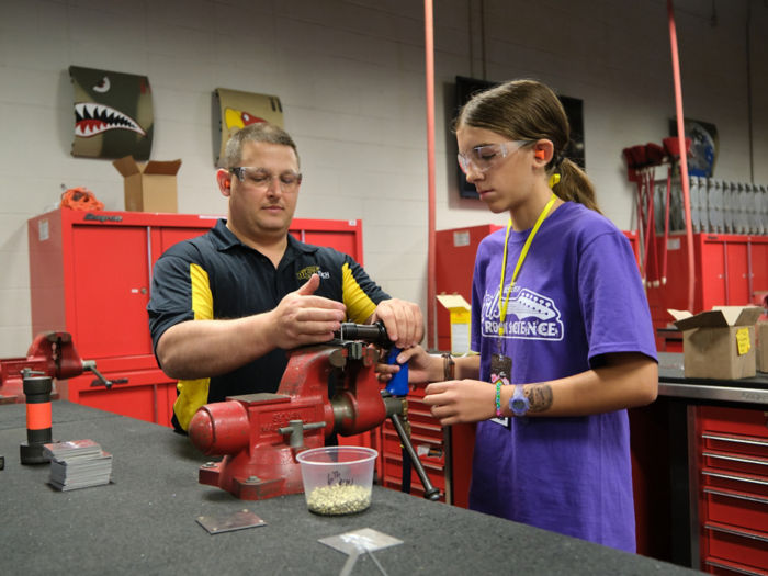 a man and woman working on a machine