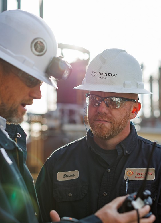 a man wearing a white hard hat and a black jacket