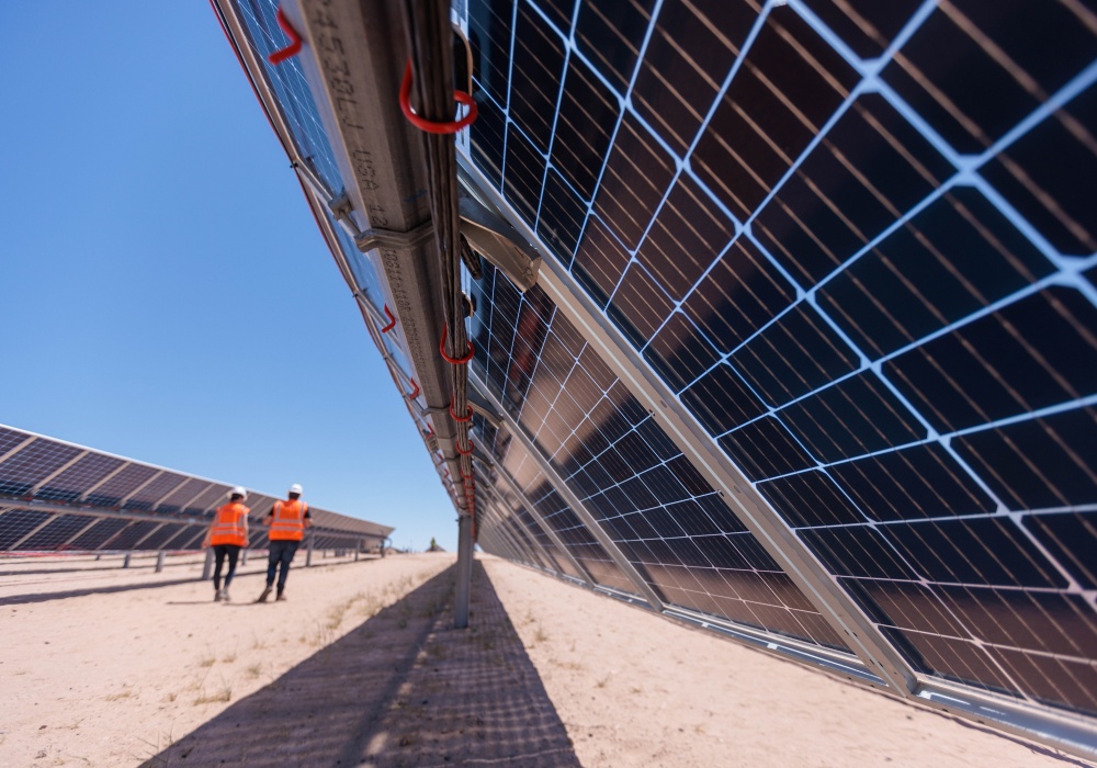 a group of people standing next to solar panels