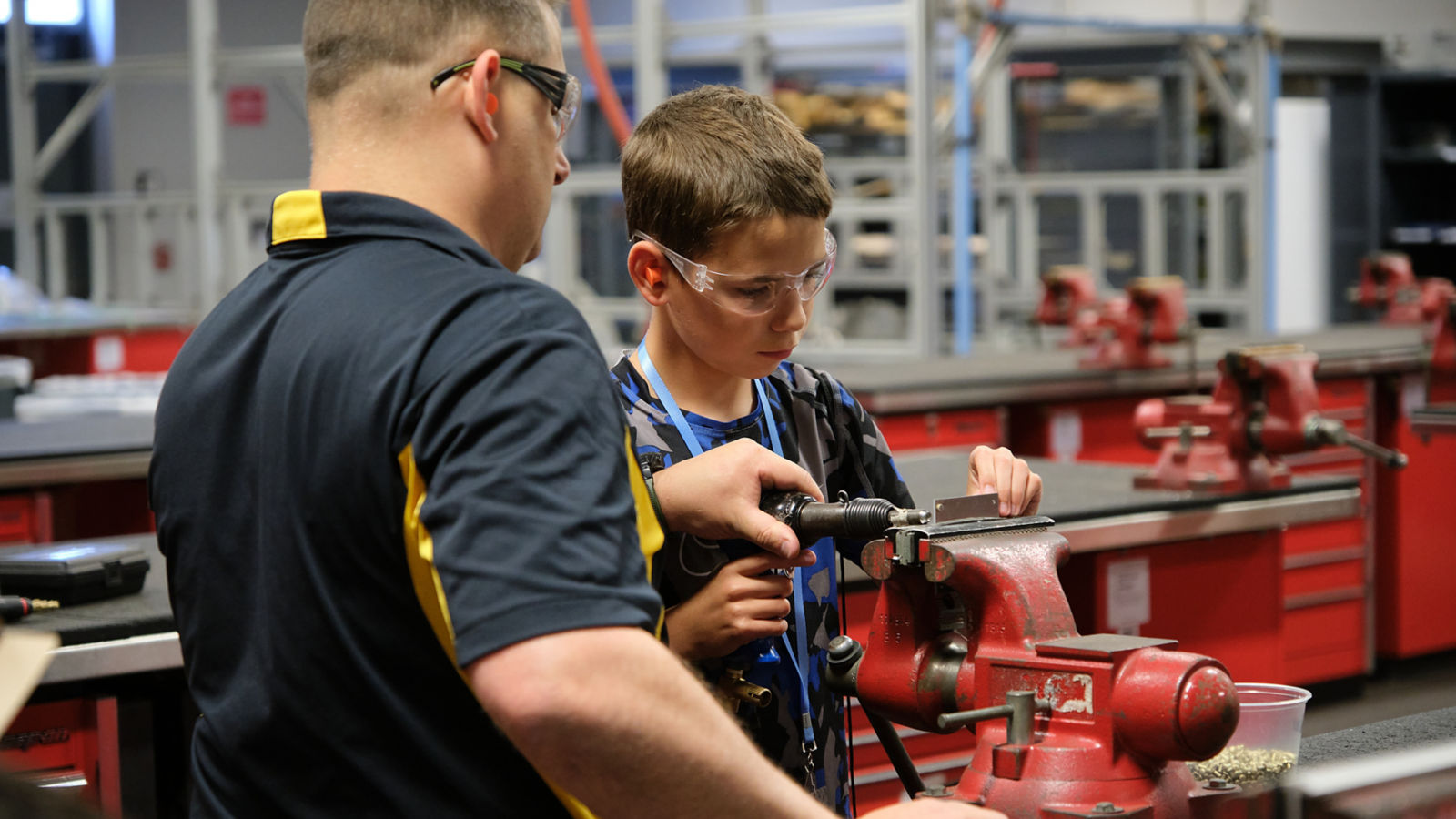 a man and boy working on a machine