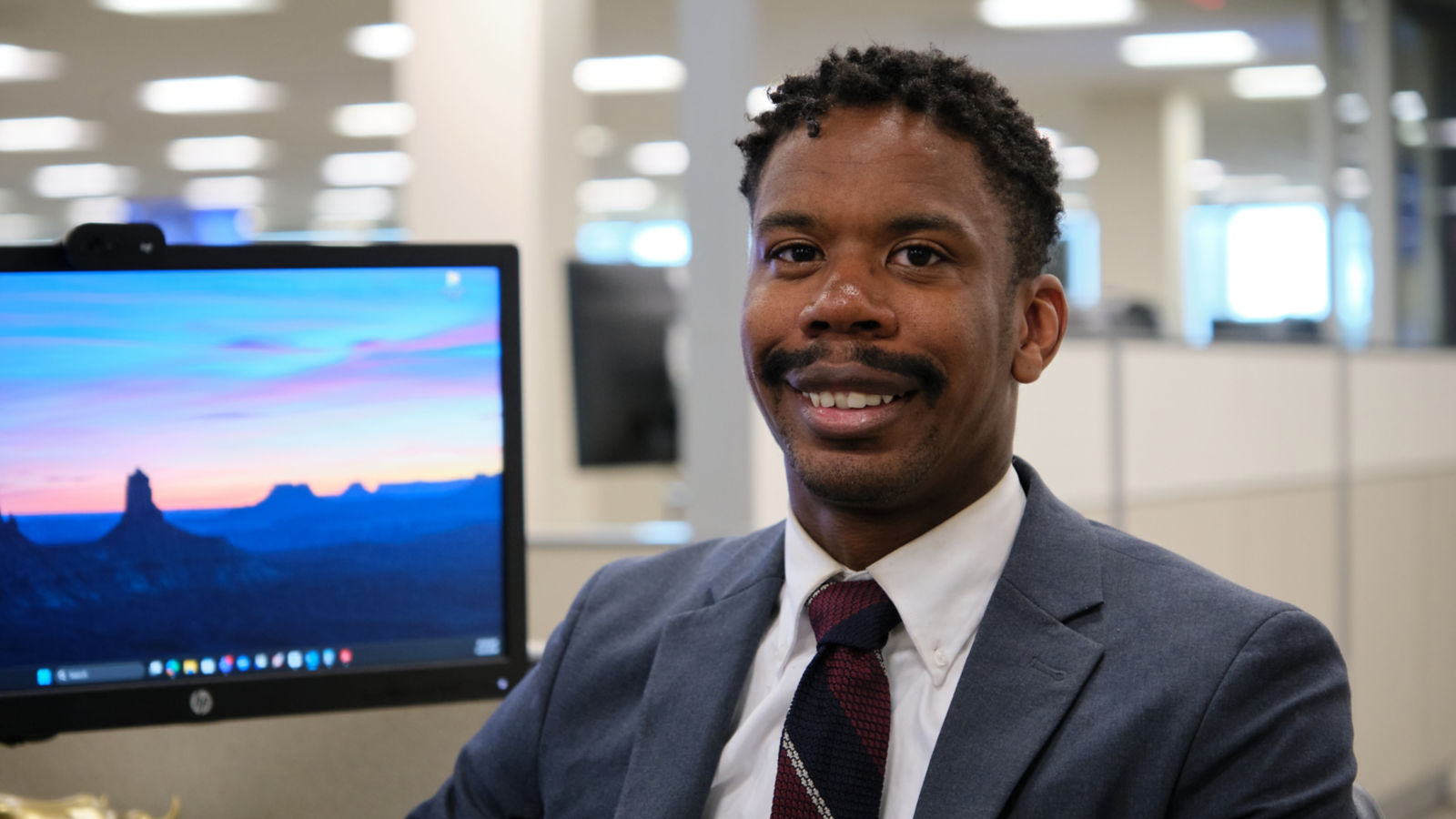 a man in a suit and tie sitting in front of a computer