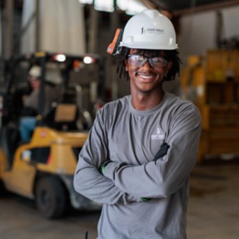 a man wearing a hard hat and crossing his arms