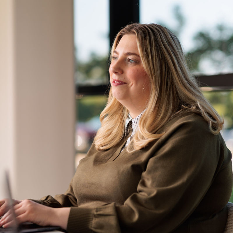 a woman sitting at a desk using a laptop