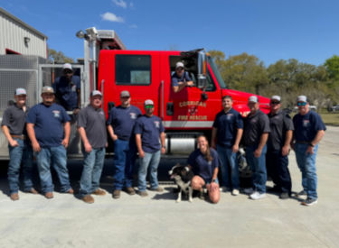 a group of people standing in front of a red fire truck