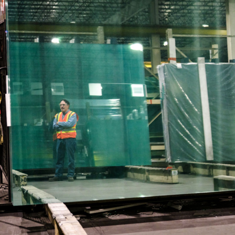 a man standing next to a large glass