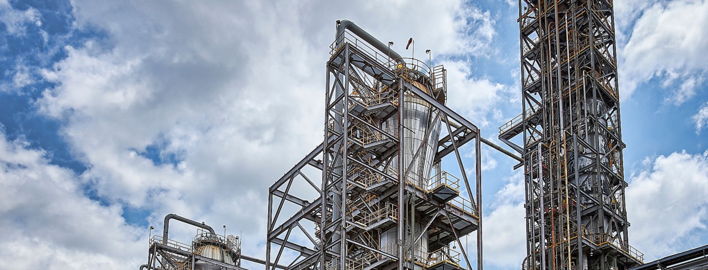 a large industrial plant with pipes and a cloudy sky
