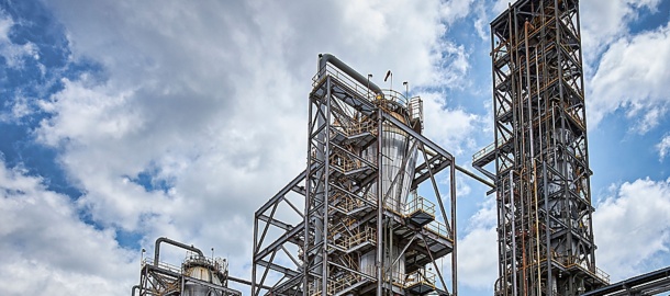 a large industrial plant with pipes and a cloudy sky