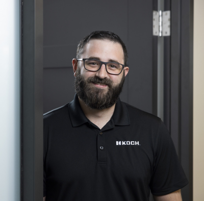 a man wearing glasses and a black polo shirt