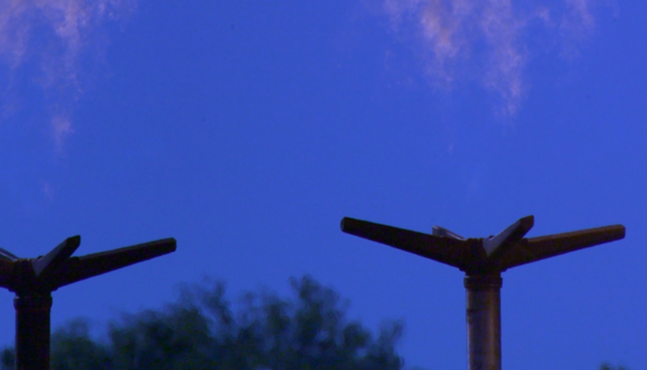 a couple of metal poles with a flame behind them