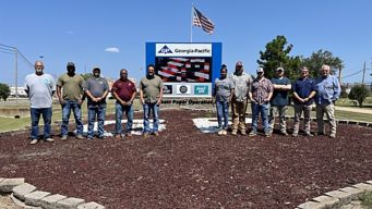 a group of men standing in front of a sign
