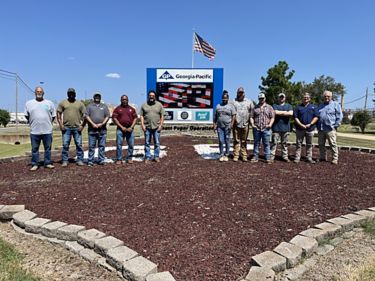 a group of men standing in front of a sign