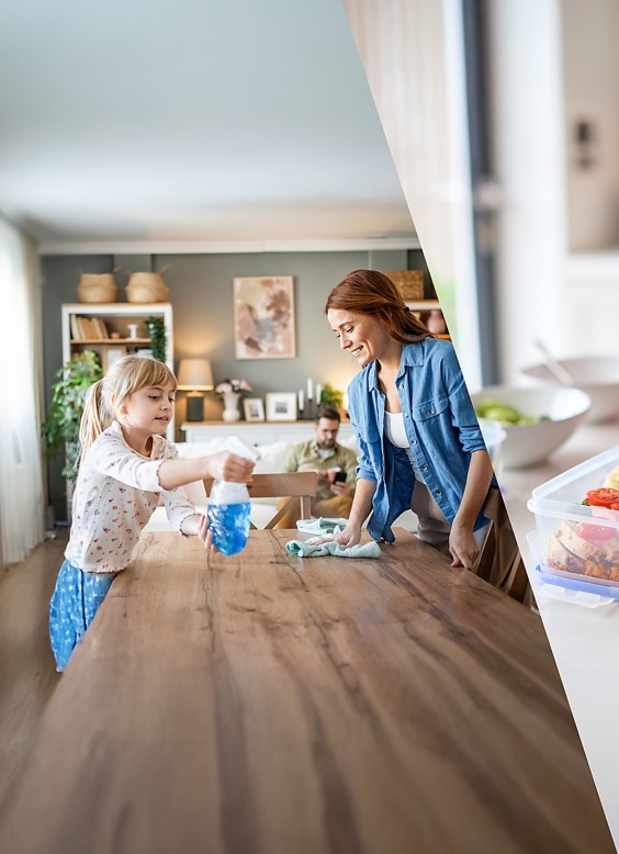 a woman and a child cleaning a table