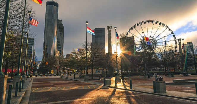 a city with a ferris wheel and flags
