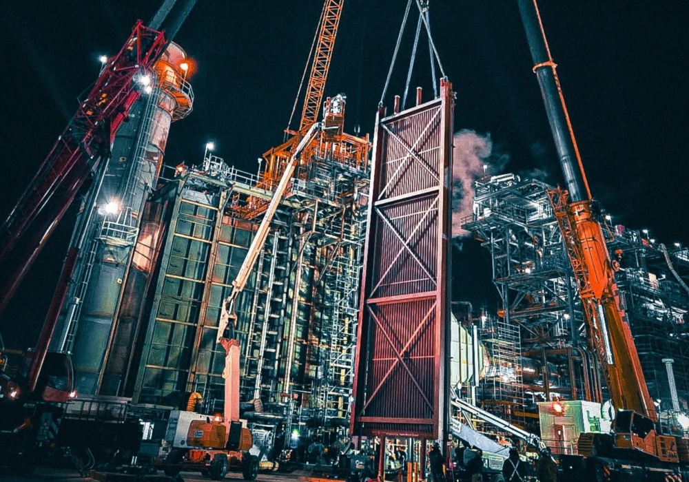 cranes lifting a metal door