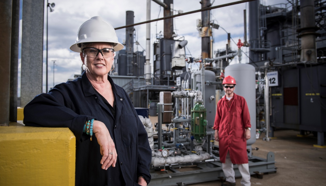 a woman in hardhat and a man in a factory