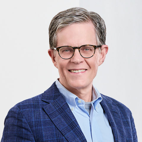 a man wearing glasses and a blue jacket