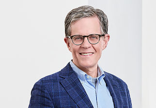 a man wearing glasses and a blue jacket