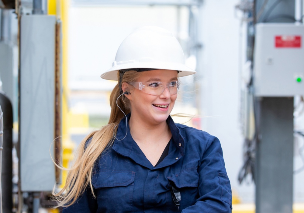 a woman wearing a hard hat and glasses