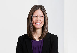 a woman wearing glasses and a black jacket