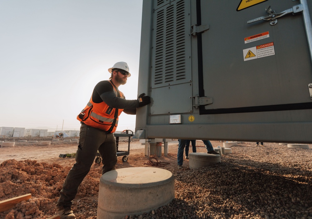 a man in a hard hat pushing a large container