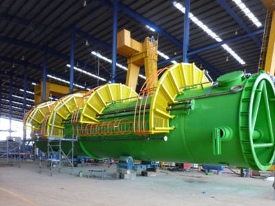 a large green and yellow machine in a factory