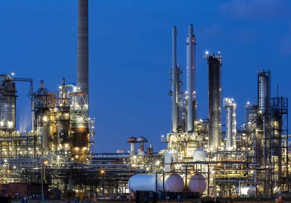 a factory at night with many towers