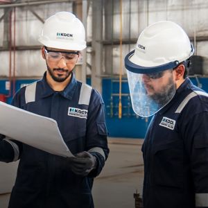 a couple of men wearing helmets and holding a paper