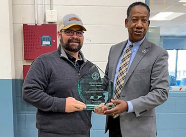 a man holding a glass award