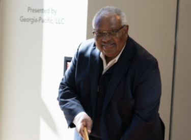 a man in a suit holding a pool stick