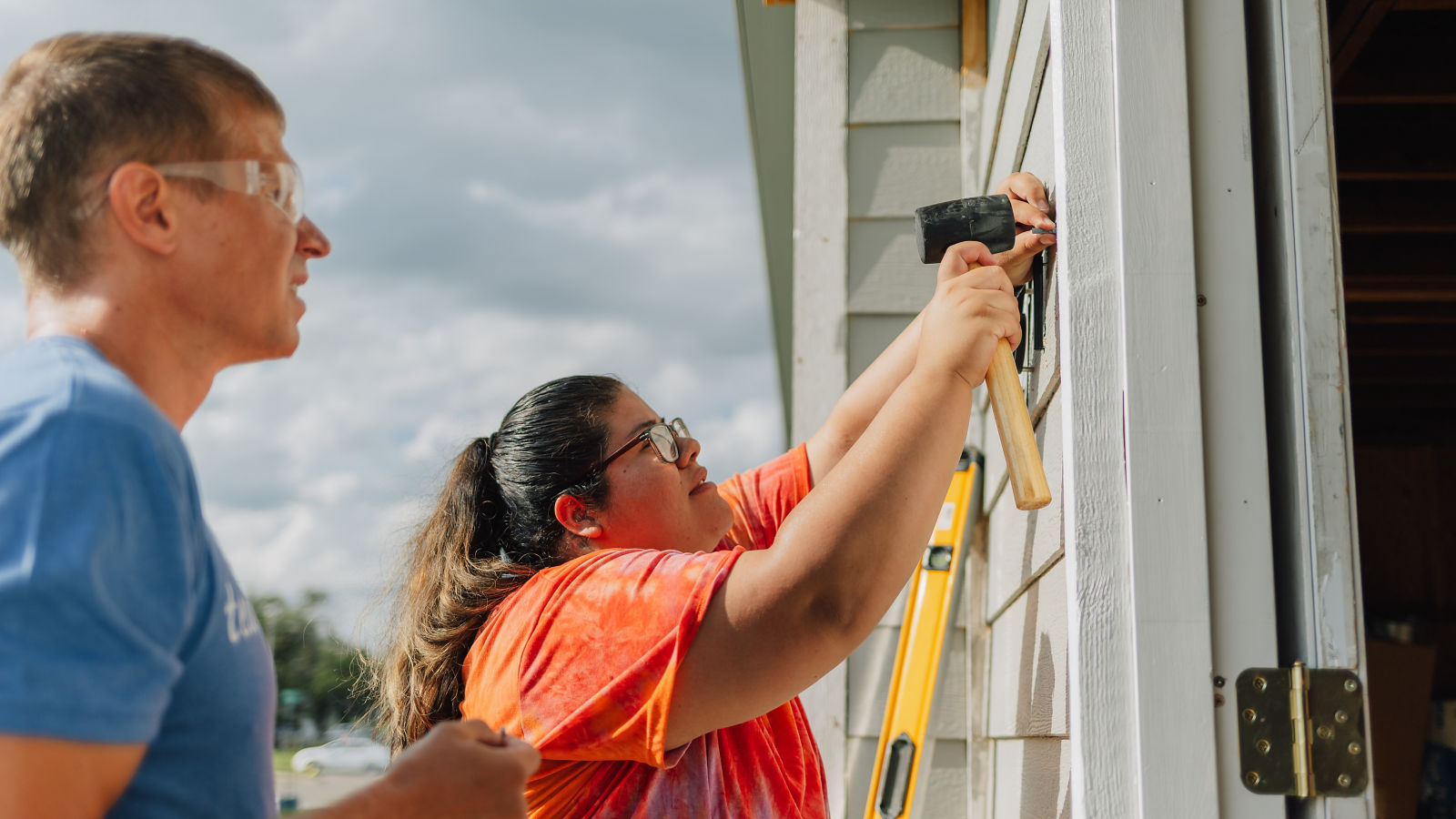 a man and woman painting a house