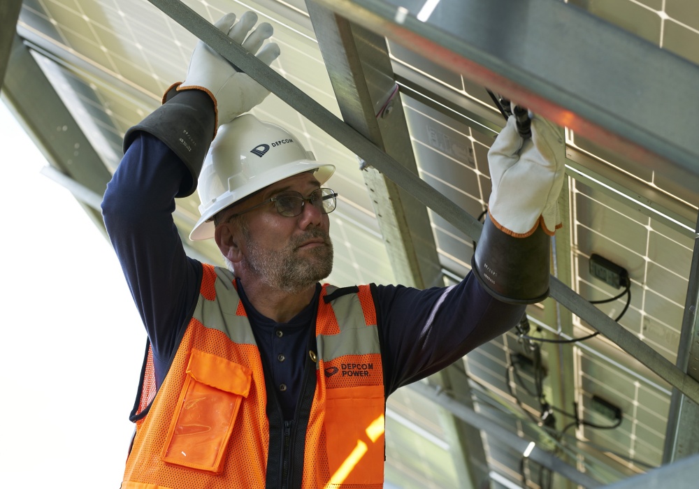a man in a reflective vest and white helmet