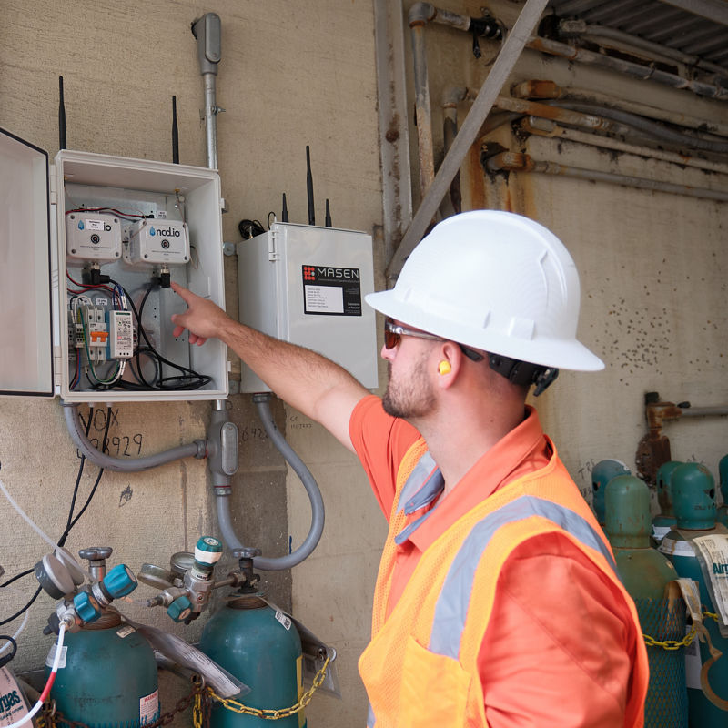 a man in a hard hat pointing at an electrical box
