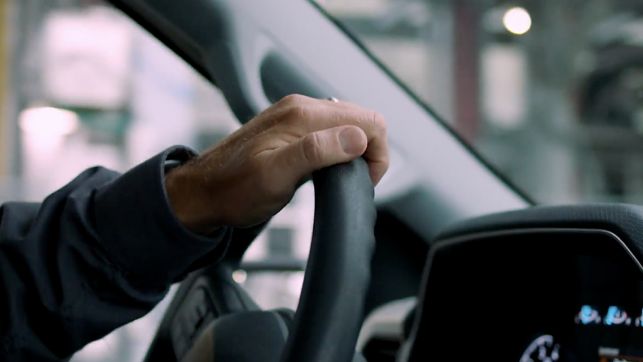 a hand holding a steering wheel