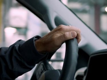 a hand holding a steering wheel