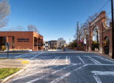 a street with a brick building and a parking lot