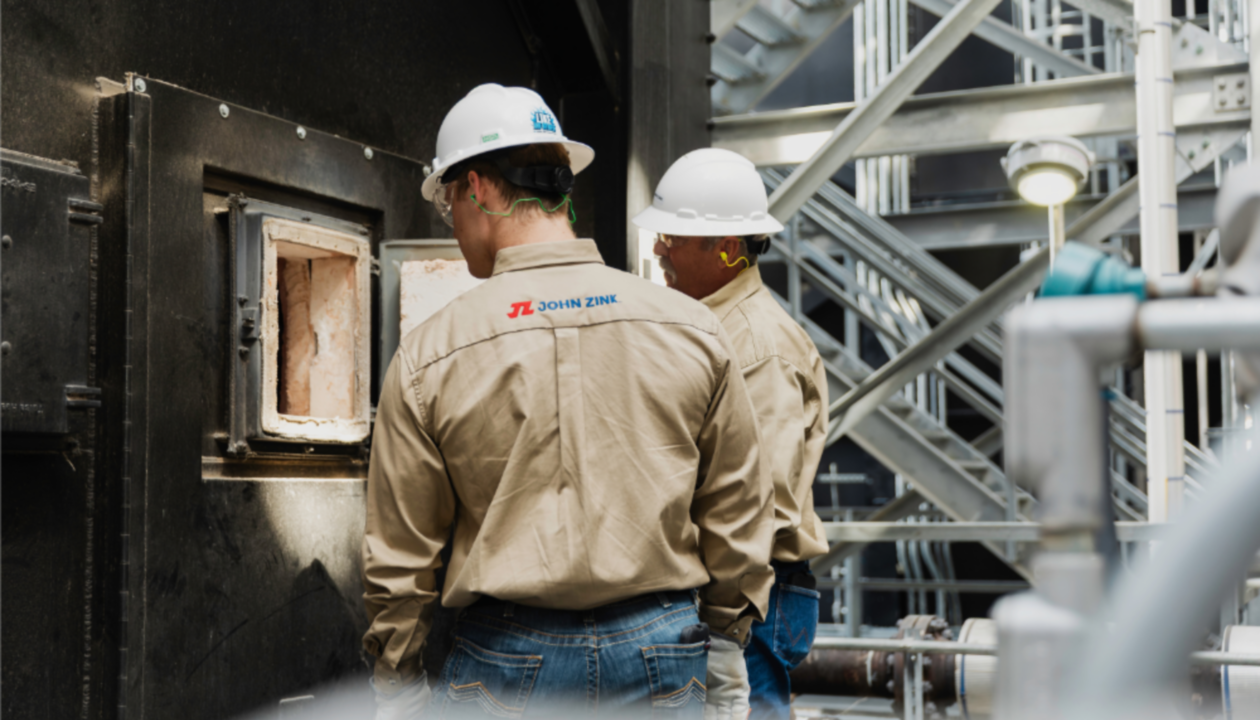 men wearing hard hats and working on a factory