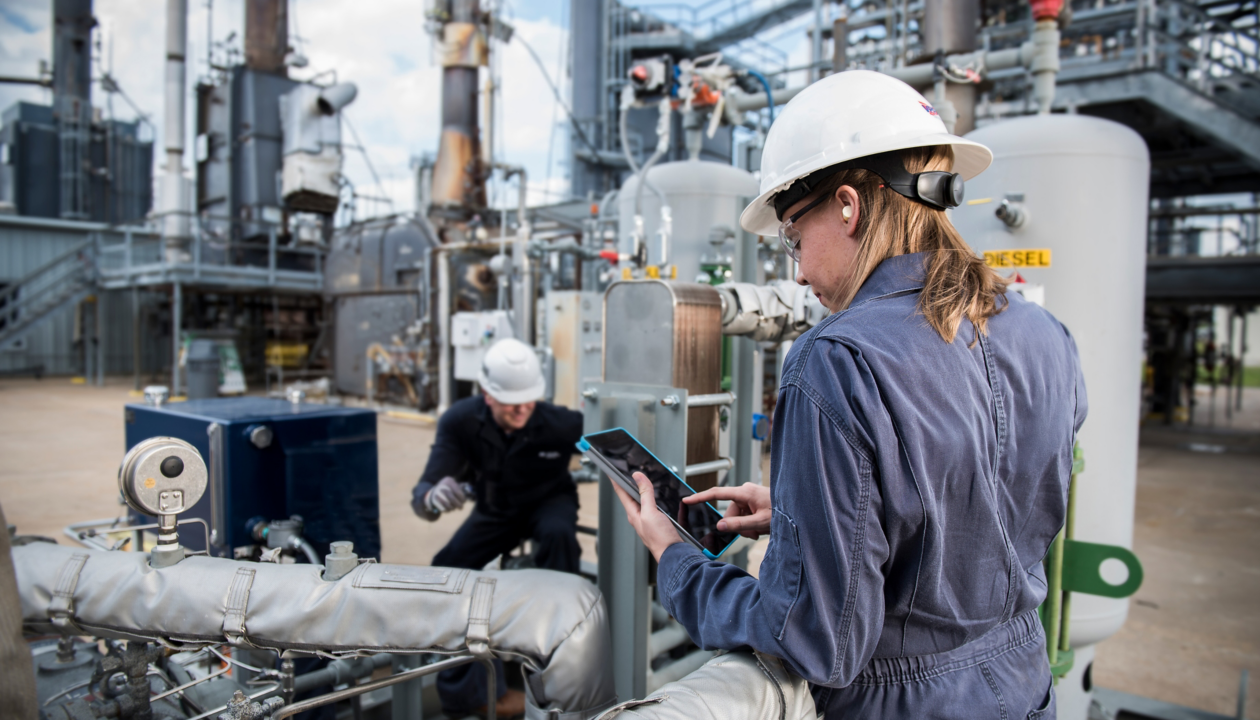 a woman in a white hard hat and blue jumpsuit