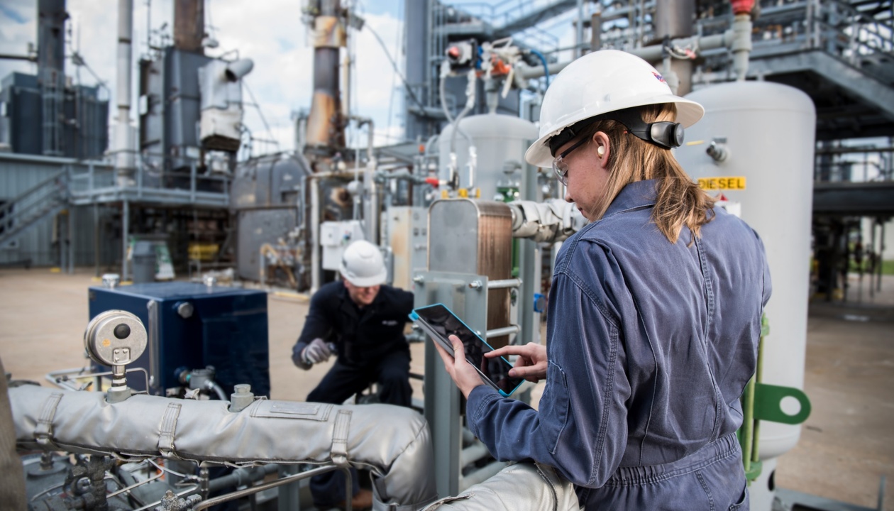 a woman in a white hard hat and blue jumpsuit