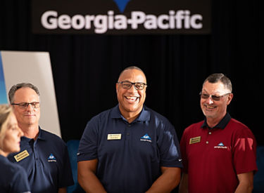 a group of men standing in front of a sign