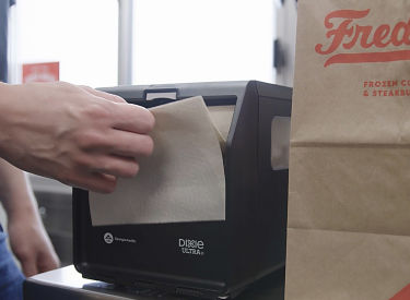a person opening a paper towel in a machine