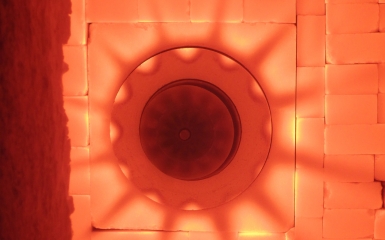 a light shining through a hole in a brick wall