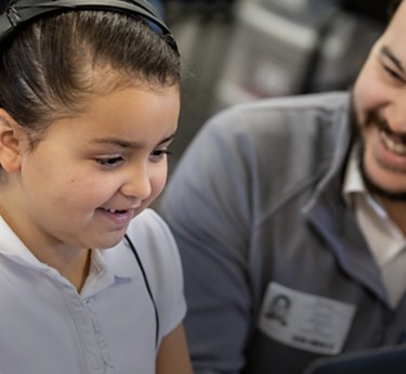 a man and a girl looking at a computer