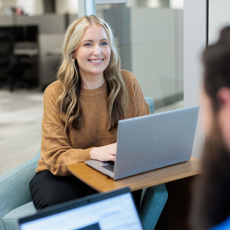a woman sitting at a table with a laptop